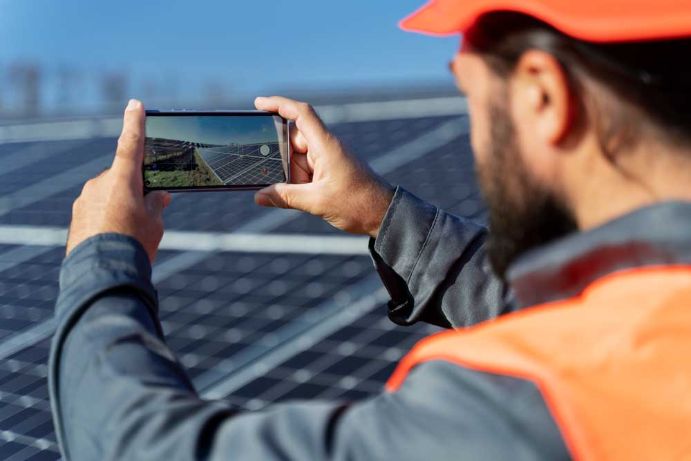 paca énergie - un homme prend une photo de panneaux solaires